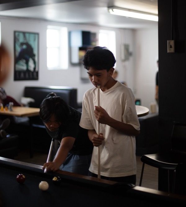 Two youth lining up a shot at the pool table at The Point