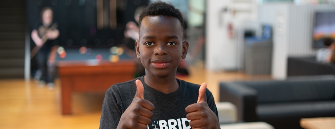 A youth giving two thumbs up in the drop-in space